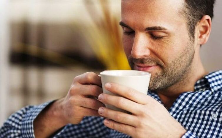 Un bărbat bea o înghițitură de ceai de fireweed pentru a crește potența